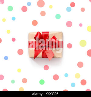Geschenkbox mit roter Schleife auf weißem Hintergrund. mit buntem Konfetti oben flach. Stockfoto