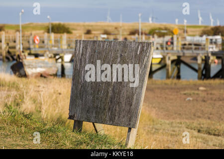 Nicht verwendete Wegweiser mit einige Boote im Hintergrund Hafen Rye, East Sussex, Großbritannien Stockfoto