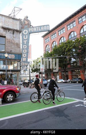 Radfahrer warten auf Ampel durch Portland Outdoor Store Bauen & äußeres Zeichen in der Innenstadt SW 3rd Avenue Portland Oregon USA KATHY DEWITT Stockfoto