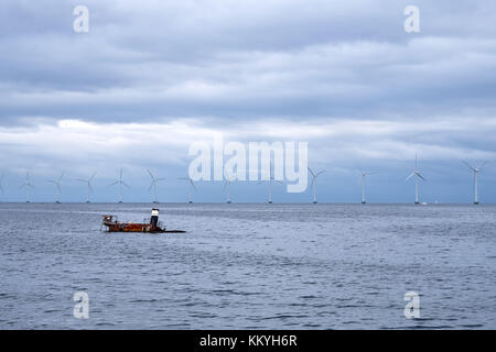 Versunkenen Schiffswrack mit nur die Spitze aus dem Wasser, mit einer Reihe von Windmühlen im Hintergrund, in der Nähe von amager Strandblick in Dänemark Stockfoto