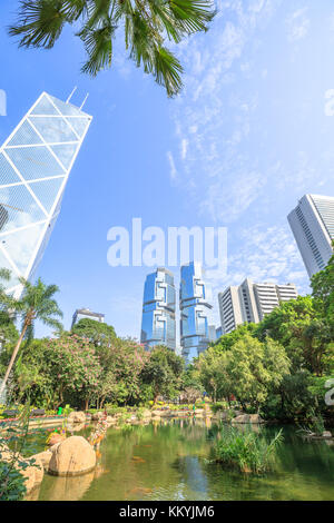 Malerischer Blick auf den Teich an der üppig grünen Garten von Hong Kong Park umgeben von modernen Wolkenkratzern im Central Business District in Hongkong Isla Stockfoto