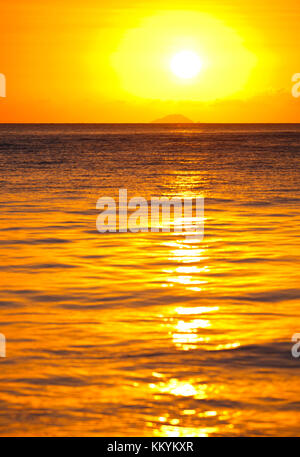 Die Insel Redonda, gehört zu Antigua und Barbuda mit einem roten Sonnenuntergang durch die Asche weg des Montserrat Volcano generiert. Stockfoto