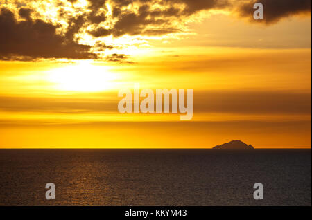 Blick von Antigua auf der Insel Redonda bei Sonnenuntergang. Die Asche Wolken vor der Sonne sind von der Soufriere Hills Vulkan auf Montserrat und Produk Stockfoto