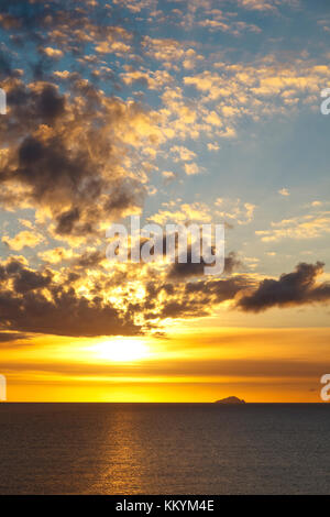 Die Insel Redonda, gehört zu Antigua und Barbuda mit einem gelben Sonnenuntergang durch die Asche weg des Montserrat Volcano generiert. Stockfoto