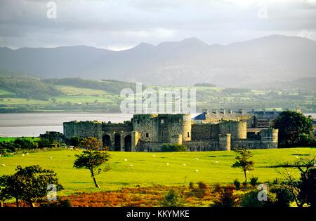 Beaumaris Castle, Anglesey, North Wales, UK mit Menai Strait und Berge von Snowdonia hinter Stockfoto