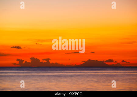 Die Insel Nevis gehört in das Land von st. Kitts und Nevis mit einem roten Sonnenuntergang durch die Asche weg des Montserrat Volcano generiert. Stockfoto