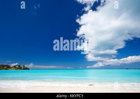 Einen sauberen weißen karibischen Sandstrand mit tiefblauen Himmel und türkisfarbenem Wasser. Stockfoto