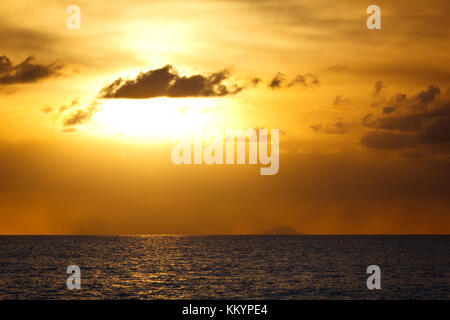 Die Insel Redonda, gehört zu Antigua und Barbuda mit einem goldenen Sonnenuntergang durch die Asche weg des Montserrat Volcano generiert. Stockfoto