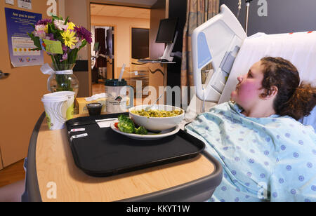 Kalispell, Montana, USA - 19. Juni 2017: Patient liegt im Bett mit einer Schüssel mit Krankenhaus Essen auf Ihr Fach Stockfoto