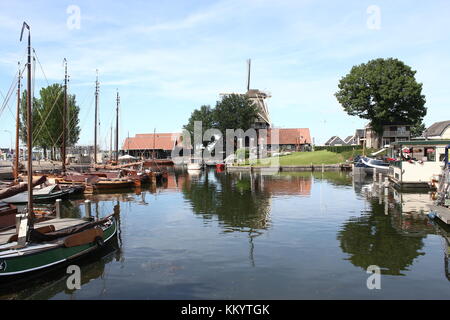 Harderwijk Vissershaven (Fischereihafen, heute Freizeit), Harderwijk, Niederlande. Im Hintergrund Getreidemühle De Hoop. Stockfoto