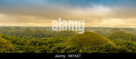 Malerischer Blick auf der UNESCO-Website der Chocolate Hills auf Bohol, Philippinen, mit Wolken und Sonne Stockfoto