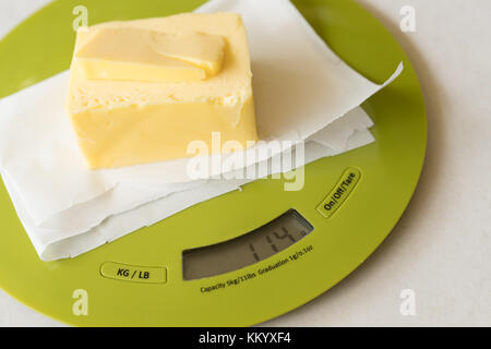 Stick der Butter auf digitale Waage in der Vorbereitung für das Backen Stockfoto