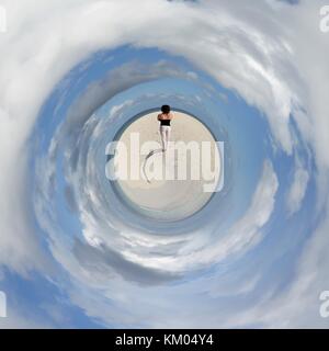 Eine junge Frau, die am Strand von einer maledivischen Insel von einer kleinen Welt Perspektive Stockfoto