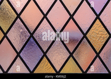 Glasmalerei mit mehrfarbige Rautenmuster als Hintergrund rosa violett Ton Stockfoto
