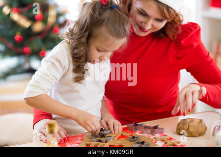 Kind und Mutter backen Weihnachten Kuchen zusammen Stockfoto