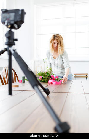 Bild der Frau im Blumenladen komponierte Strauß rosa Blüten. Datensatz resin auf Video Kamera Stockfoto