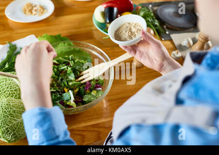 Hinzufügen von Würze zu Salat Stockfoto