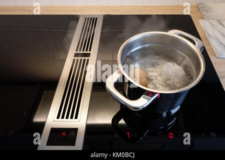 Topf mit kochendem Wasser und Eier auf einer Induktion Herd in der Küche Stockfoto