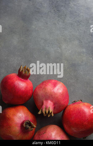 Reife rote organische Granatäpfel an schwarzen Stein Hintergrund poster Vorlage banner Herbst Thanksgiving Rosch Haschanah Kopie Raum Stockfoto