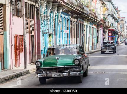 Ein paar alte amerikanische Autos aus den 50er Jahren Reisen entlang eine bunte Straße eines Morgens im Centro Havanna, die rauhe Seite der kubanischen Hauptstadt, während Stockfoto