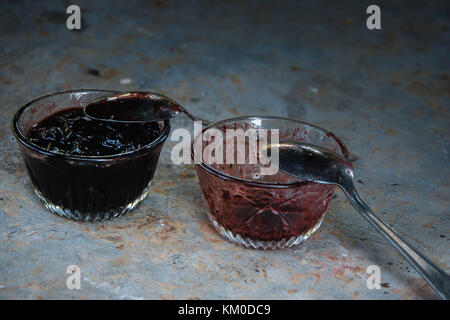 Zwei Schalen mit hausgemachter Marmelade, eine leer ist und man ist voll. gierig Konzept Stockfoto