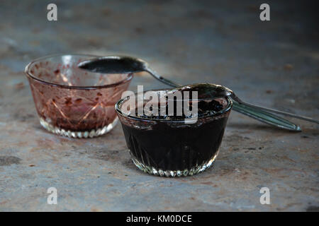 Zwei Schalen mit hausgemachter Marmelade, eine leer ist und man ist voll. gierig Konzept Stockfoto