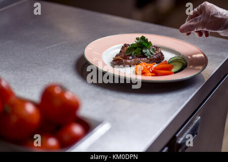 Chef beendete seine Platte und fast fertig am Tisch zu dienen Stockfoto