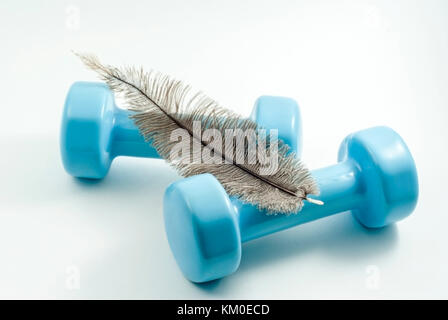 Paar hellblau Hanteln für Fitness Training und Lügen über Sie ein straussenfedern auf weißem Hintergrund Stockfoto