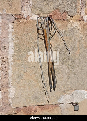 Rostige Werkzeuge closeup auf Steinmauer in Mallorca, Balearen, Spanien Stockfoto