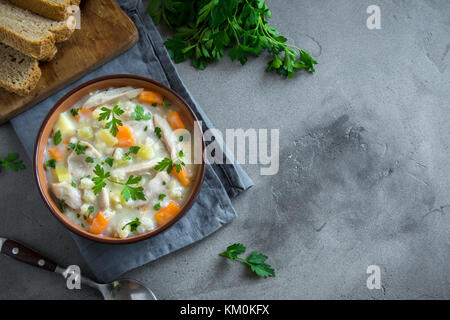 Hühnersuppe. hausgemachte Frische cremige Suppe mit Hähnchen, Gemüse und Grüns in der Schüssel. Stockfoto