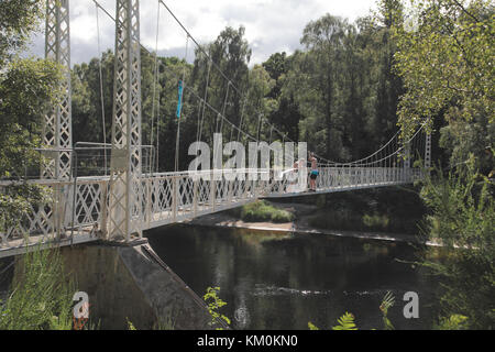 Jungs, die gerade von der Cambus O’May Fußgängerbrücke über den Fluss Dee springen, der in Storm Frank schwer beschädigt wurde Stockfoto