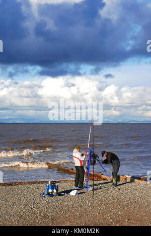 Sea angler Fisch an einem kalten, stürmischen, Winter tag auf dem Lacashire Küste an Fleetwood Stockfoto