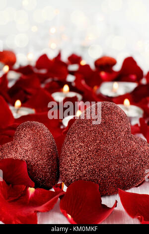 Valentinstag Herzen durch Rosenblätter und lite Kerzen vor einem weißen Hintergrund umgeben. Zimmer für Kopie Raum mit extrem geringer Tiefenschärfe. Stockfoto