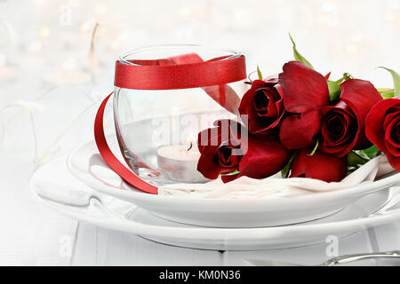 Romantischen candlelite Tabelle Einstellung mit langem Stiel Rote Rosen und Kerzen im Hintergrund. geringe Tiefenschärfe mit selektiven Fokus auf Rosen. Stockfoto