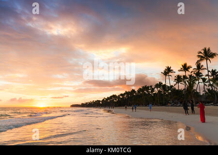 Punta Cana, Dominikanische Republik - 5. Januar 2017: Gewöhnliche Menschen spazieren am Sonnenaufgangsstrand von Punta Cana Stockfoto