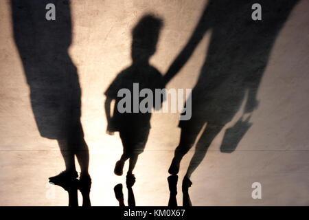 Verschwommene Schatten der Mutter mit Sohn Hand in Hand und ein Mann stand neben Ihnen Stockfoto