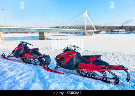 Schnee Mobiles an der Kerze Brücke in den zugefrorenen See im Winter Rovaniemi, Lappland, Finnland Stockfoto