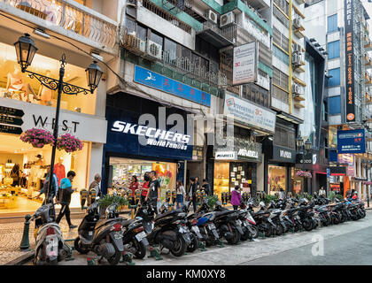 Macao, China - 8. März 2016: Menschen und Motorräder im Downtown Shopping Center von Macau. Stockfoto