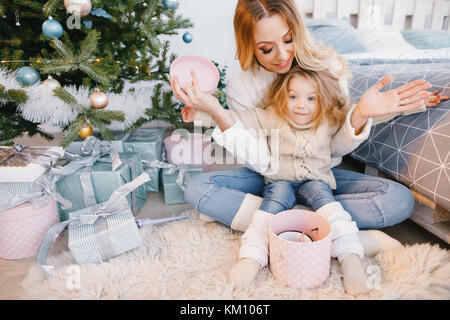 Mama und Tochter öffnen Geschenke Stockfoto