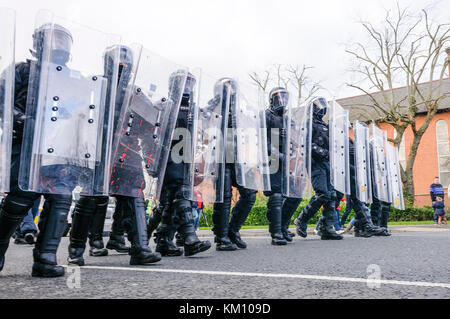 16. Februar 2013, Belfast, Nordirland, Großbritannien. PSNI Polizisten in Kampfausrüstung mit Armadillo Crowd Control schirmt halten eine Menge bewegen Stockfoto