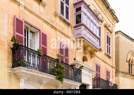 Balkonen und Fensterläden auf einem Gebäude in der Maltesischen ummauerten Stadt Mdina. Stockfoto