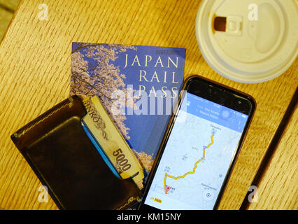 Nagoya, Japan - Dec 3, 2016. Japan Rail Pass mit iphone und Brieftasche zu JR-Bahnhof in Nagoya, Japan. die Eisenbahnen sind das wichtigste Mittel der Beifahrerseite Stockfoto