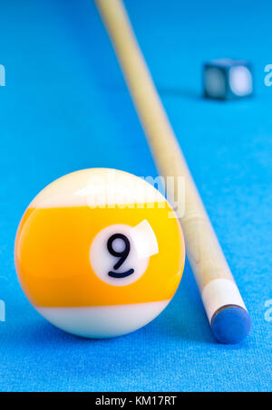 Billard Pool Spiel 9-Ball mit Kreide und Cue auf Billardtisch mit blauem Tuch Stockfoto