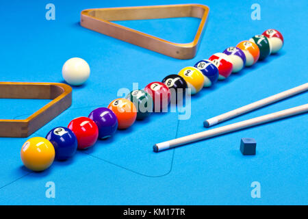 Billard Pool Spielbälle aufgereiht auf Billardtisch mit blauem Tuch mit Cues, Racks, und Kreide Stockfoto