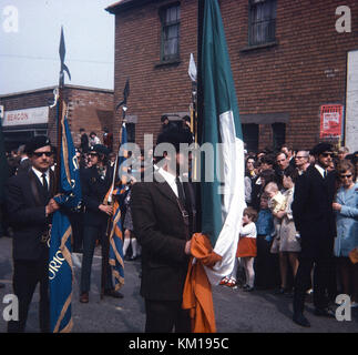 IRA Farbe Partei und republikanische Ostern Parade auf beechmount Avenue West Belfast 1970. Diese Ostern Parade signalisiert die Spaltung zwischen der offiziellen und der Provisional IRA. Der Official IRA verwendet Stick auf Ostern Lillies (so wurde als die Stickies bekannt) und die Provisional IRA trug Stift auf der Abzeichen. Dies ist die PIN auf Parade Stockfoto