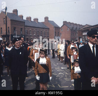 IRA Farbe Partei und republikanische Ostern Parade auf beechmount Avenue West Belfast 1970. Diese Ostern Parade signalisiert die Spaltung zwischen der offiziellen und der Provisional IRA. Der Official IRA verwendet Stick auf Ostern Lillies (so wurde als die Stickies bekannt) und die Provisional IRA trug Stift auf der Abzeichen. Dies ist die PIN auf Parade Stockfoto