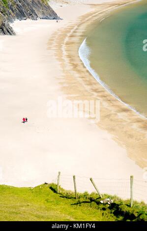 Menschen, die am Silver Strand in Malin Beg spazieren gehen, in der Nähe von Glencolumbkille, County Donegal. West End der Slieve League Klippen Stockfoto