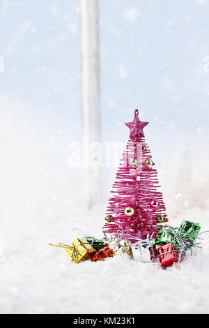 Winter Szene von Pink retro Weihnachtsbaum durch Geschenke vor einem Fenster umgeben. Stockfoto