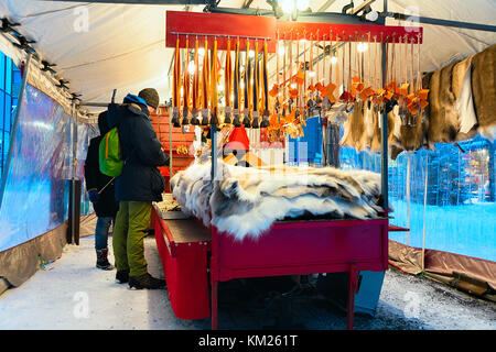 Menschen am Markt mit traditionellen Souvenirs wie Rentierfell und Hörner im Winter Rovaniemi, Lappland, Finnland. Stockfoto