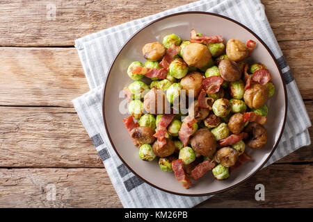 Gebratene Kastanien, Rosenkohl und Speck closeup auf einem Teller. horizontal oben Ansicht von oben Stockfoto